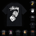 Black Stssy T-shirt from Theplugcrew laid flat, showcasing the front design and classic fit, made from soft cotton material.